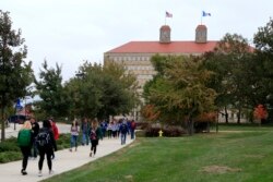 In this Oct. 24, 2019, file photo students walks in front of Fraser Hall on the University of Kansas campus in Lawrence, Kan. Americans collectively owe nearly $1.5 trillion in student loans, more than twice the total a decade ago.