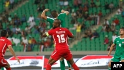 Pesepak bola Palestina (tengah) mengincar bola dengan pemain Irak dalam pertandingan persahabatan internasional antara Irak dan Palestina di Stadion Olahraga Kota Basra, 8 Mei 2018.
