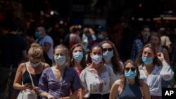 Tourists wearing face masks wait to cross a road in downtown Barcelona, Spain, Thursday, July 16, 2020. With Europe's summer vacation season kicking into high gear for millions weary of months of lockdown, scenes of drunken British and German…