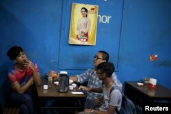 Beberapa pria bersantai di sebuah kedai teh sambil merokok, di Yangon, Myanmar, 6 November 2015