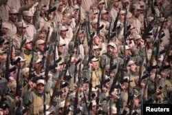 Fighters from the self-defense forces of the Kurdish-led north hold their weapons during a rally in Hasaka, northeastern Syria, Jan. 23, 2018.