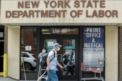 Pejalan kaki melewati kantor Departemen Tenaga Kerja Negara Bagian New York, di wilayah Queens, New York, 11 Juni 2020. (Foto: dok).