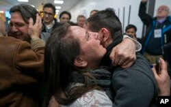 FILE - Family members who have just arrived from Syria embrace and are greeted by family who live in the United States upon their arrival at John F. Kennedy International Airport in New York, Feb. 6, 2017.