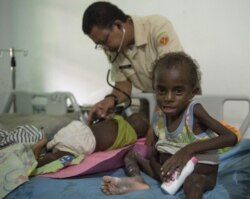 Anggota Satgas TNI memeriksa anak di rumah sakit setempat di Agats, Ibu Kota Kabupaten Asmat pada 26 Januari 2018.(Foto: AFP/Bay Ismoyo)