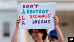 Trump ImmigrationJulia Paley, of Arlington, Va., with the DMV Sanctuary Congregation Network, holds up a sign during a rally supporting Deferred Action for Childhood Arrivals, or DACA, outside the White House, in Washington, Sept. 4, 2017.
