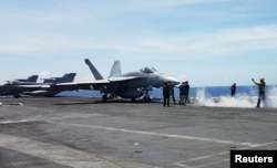 An F18 fighter prepares to take off at the flight deck of the USS Theodore Roosevelt while transiting the South China Sea, April 10, 2018.