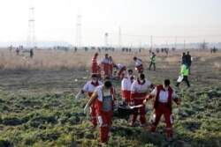 8일 이란 테헤란 이맘호메이니 국제공항 인근에서 우크라이나 여객기가 추락하는 사고가 발생한 후 구조대원들이 시신을 옮기고 있다.
