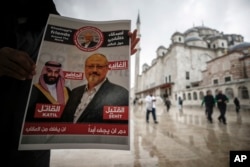 A man holds a poster showing images of Saudi Crown Prince Muhammed bin Salman and of journalist writer Jamal Khashoggi, describing the prince as "assassin" and Khashoggi as "martyr" during funeral prayers in absentia for Khashoggi who was killed at the Saudi consulate in Istanbul on Oct. 2, 2018.