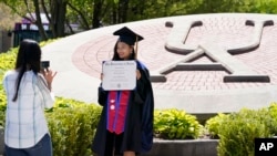 지난해 미국 오하이오주 애크런대학교 졸업생이 교정에서 기념사진을 찍고 있다. (자료사진)