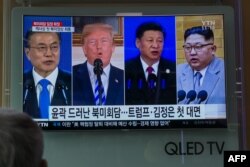 FILE - People watch a screen showing images of, from left, South Korea's president Moon Jae-in, U.S. president Donald Trump, China's president Xi Jinping, and North Korea's leader Kim Jong Un at a railway station in Seoul, May 11, 2018.