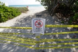 Pengumuman dilarang masuk tampan di pantai Surfside, Florida, Sabtu, 21 Maret 2020. (Foto: AP)