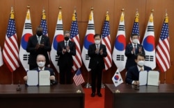 지난 18일 방한 중인 미국의 토니 블링턴 국무장관과 로이드 오스틴 국방장관, 한국의 정의용 외교장관과 서욱 국방장관이 서울 외교부 청사에서 진행된 한미 방위비분담특별협정(SMA) 가서명식에 참석한 가운데 로버트 랩슨 주한 미국대사 대리(왼쪽)와 정은보 외교부 한미 방위비분담금 협상대사가 서명 후 합의문을 들어 보이고 있다.