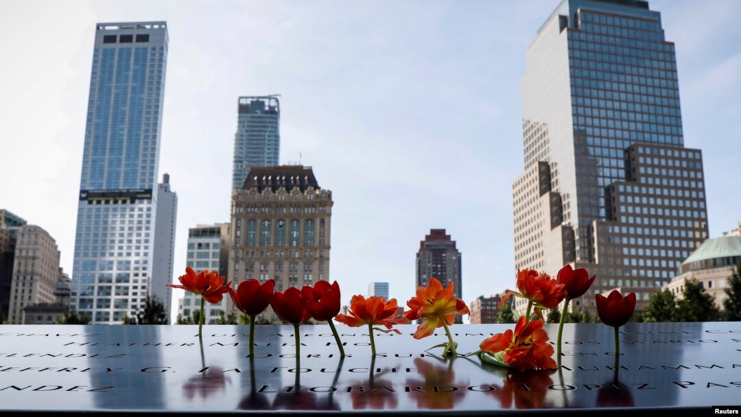 罹難者親屬在世貿中心雙子樓遺址現在是兩個方形紀念水池，插上鮮花。