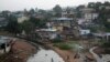 Kids jump on tires to cross a stream in a slum in Freetown, Sierra Leone, Dec. 16, 2014. 
