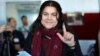 Fawza Youssef, a senior Kurdish politician, shows her ink-stained finger after casting her ballot in Qamishli, Syria, Dec. 1, 2017.