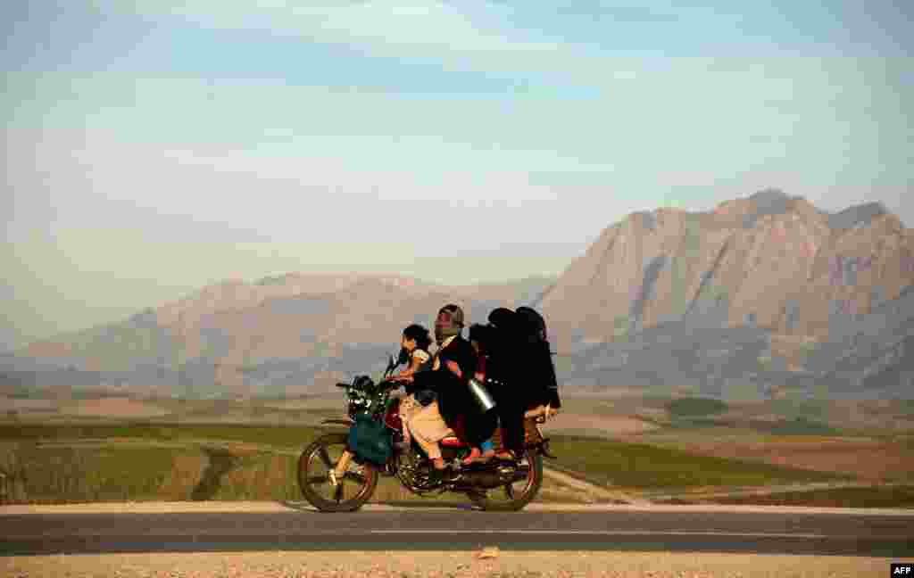 Sekeluarga mengendarai sebuah sepeda motor di Afghanistan di pinggaran Mazari-i-Sharif pada hari raya Nowruz yang menandaikan Tahun Baru Afghanistan.