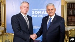 PM Turki Binali Yildirim (kanan) berjabat tangan dengan Menhan AS James Mattis dalam pertemuan di London, Kamis (11/5). 