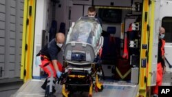 An empty stretcher is carried back into an ambulance which is believed to have transported Alexei Navalny at the emergency entrance of the Charite hospital in Berlin, Germany, Saturday, Aug.22, 2020. 
