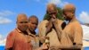 FILE - Youths covered in dust work at an open-pit gold mine in Lukingi village in Mubende district, about 150 km (90 miles) southwest of Uganda's capital Kampala.