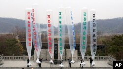 FILE - In this April 15, 2011 file photo, Park Sang Hak, center, a refugee from the North who now runs the group Fighters for a Free North Korea from a small Seoul office, and South Korean conservative activists prepare to release balloons bearing…