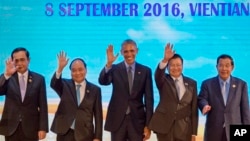 Presiden Amerika Serikat Barack Obama (tengah) bersama para pemimpin ASEAN melambaikan tangan saat berfoto bersama di Vientiane, Laos, 8 September 2016 (AP Photo/Gemunu Amarasinghe).