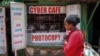 Seorang pejalan kaki berjalan melewati sebuah warung internet di wilayah miskin Kibera di Nairobi, Kenya, pada 29 September 2021. (Foto: AP/Brian Inganga)