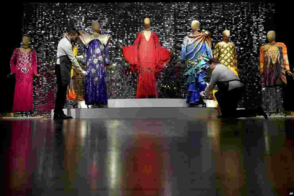 Art handlers arrange costumes during a photo opportunity ahead of the Barry Humphries: The Personal Collection sale at Christie's auction rooms in London. Items belonging to the late Australian comedian are to be auctioned Feb. 13 in a sale estimated at 2 million to 4 million pounds ($2.49 million to $4.98 million).