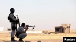 FILE - Kurdish Peshmerga troops participate in an intensive security deployment against Islamic State militants in a village on the outskirts of the province of Nineveh near the border province of Dohuk, Iraq, Aug. 9, 2014. 