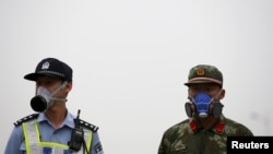 在天津大爆炸现场头带防毒面具的中国警察和武警士兵 （2015年8月18日）