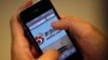 FILE - A man holds an iPhone as he visits China's Weibo microblogging site in Shanghai, May 29, 2012. Weibo has partnered with U.S.-based rating agency Nielson's to gauge marketing possibilities on the platform.