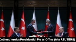 Presiden Turki Tayyip Erdogan dan Presiden Polandia Andrzej Duda menyaksikan upacara penandatanganan perjanjian yang dilakukan oleh Menteri Pertahanan kedua negara di Ankara, Turki, Senin, 24 Mei 2021. (Foto: Murad Cetinmuhurdar/Kantor Pers Kepresidenan v
