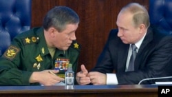 Presiden Rusia Vladimir Putin (kanan) berbicara dengan Kepala Angkatan Bersenjata Rusia, Jenderal Valery Gerasimov dalam pertemuan di Moskow, 11 Desember 2015 (foto: dok).