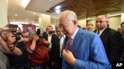 Former Malaysian Prime Minister Najib Razak, center, walks out from the courtroom at the court house in Kuala Lumpur, Malaysia, for his corruption trial, Dec. 3, 2019.