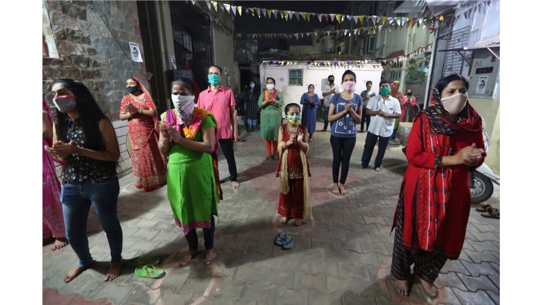 Indians, wearing face mask and maintaining physical distance, participate in religious rituals during Navratri or nine nights festival celebrations in Ahmedabad, Oct. 21, 2020.