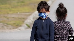Arhiva - Izbeglička deca nose maske kako bi se zaštitila od Kovida 19, dok se igraju tokom akcije vakcinacije u izbegličkom centru "Krnjača" kraj Beograda, Srbija, 26. marta 2021.