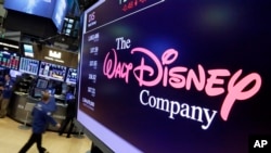 FILE - In this Aug. 8, 2017, file photo, The Walt Disney Co. logo appears on a screen above the floor of the New York Stock Exchange.