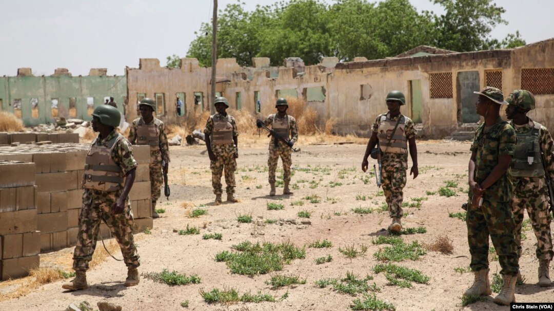FILE - Soldiers walk among the ruins of the Government Secondary School in Chibok, Nigeria, March 25, 2016.