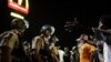 FILE - Officers and protesters face off along West Florissant Avenue in Ferguson, Mo., Aug. 10, 2015. The city and the U.S. Justice Department have reached an agreement over police reform.