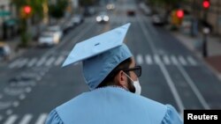 Seorang lulusan program pascasarjana dari Universitas Columbia tampak di kampusnya seehari sebelum upacara wisuda, yang akan diadakan secara daring karena wabah virus corona (Covid-19) di Manhattan, New York, 15 Mei 2020. (Foto: Reuters) 