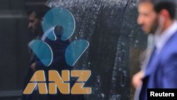 FILE - A pedestrian is reflected in the window of a branch of the Australia and New Zealand Banking Group (ANZ) in central Sydney, Australia, Oct. 25, 2017.
