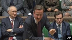Britain's Prime Minister David Cameron (C) is flanked by Chancellor of the Exchequer George Osborne (R) and Leader of the House of Commons George Young during a parliamentary debate on last week's European Union summit, in London, December 12, 2011.