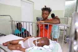 Dorvil Chiloveson, 3, swollen with edema, is watched over by his mother Linda Julien, 20, in the malnutrition ward at St. Damien Pediatric Hospital in Port-au-Prince, Haiti, Jan. 29, 2020.