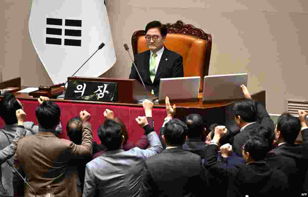 South Korea's ruling People Power Party lawmakers, bottom, argue to National Assembly Speaker Woo Won-shik during the plenary session for the impeachment vote of acting president Han Duck-soo at the National Assembly in Seoul.