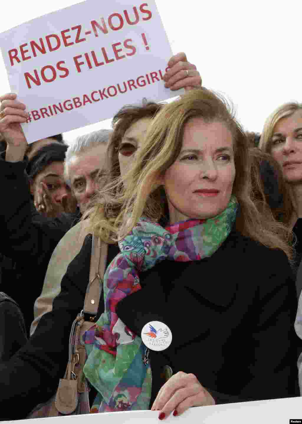 Former French first lady Valerie Trierweiler stands near a placard that reads "Bring back our girls" during a demonstration to pressure government leaders to help search for the Nigerian schoolgirls, near the Eiffel Tower, Paris, May 13, 2014. 