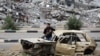 A Palestinian child stands inside a damaged car in front of a destroyed building in the war-devastated Bureij refugee camp in the central Gaza Strip, Feb. 7, 2025. 