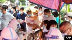 中国湖北武汉市民排队接受新冠病毒核酸检测。（2021年8月3日）