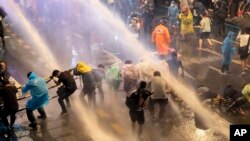 在泰国首都曼谷，警察们试图用水枪驱散抗议者们。（2020年10月16日）
