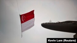 Bendera nasional Singapura dikibarkan oleh helikopter Chinook CH-47SD. Singapura akan memberlakukan "sanksi dan pembatasan yang pantas" pada Rusia.(Foto: REUTERS/Kevin Lam)