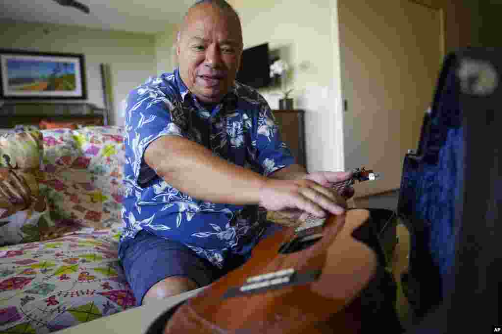 Charles Nahaale holds a ukulele gifted by his friend after Nahale lost most of his instruments from August's wildfire on Oct. 10, 2023, in Lahaina, Hawaii. 