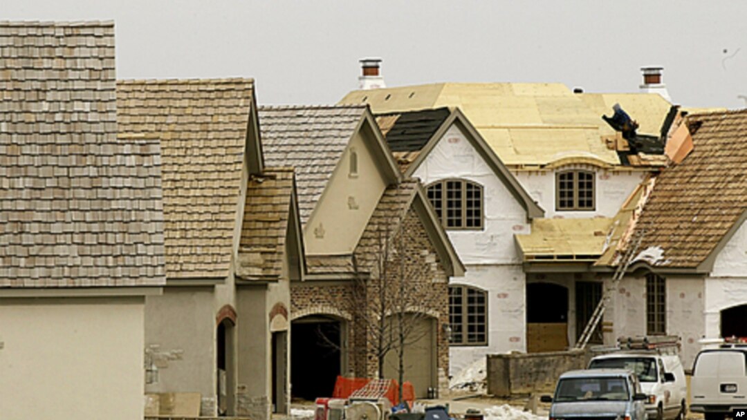 A construction worker puts a roof on a house in a western suburb of Chicago, (File).